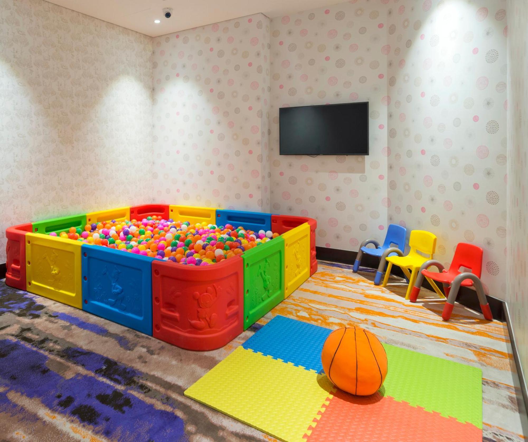 Canal Central Hotel Business Bay Dubai Exterior foto The photo shows a colorful children's play area. It features a large ball pit surrounded by bright, plastic walls in red, yellow, and green. The ball pit is filled with numerous multicolored plastic balls. Nearby, there are several small, brightly co